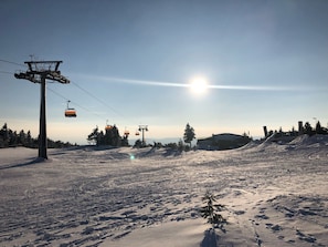 Un télésiège, un ciel dégagé et un paysage enneigé.