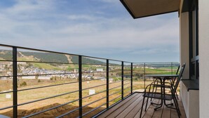 A wooden deck with a metal railing overlooking a town and hills. - Bella Vista by Interhome (Loucna pod Klínovcem)