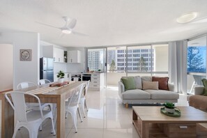 A modern apartment with a kitchen, dining area, and living room.
