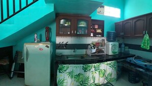 A kitchen with a refrigerator, sink, and cabinets. - Bronk House (Yogyakarta)