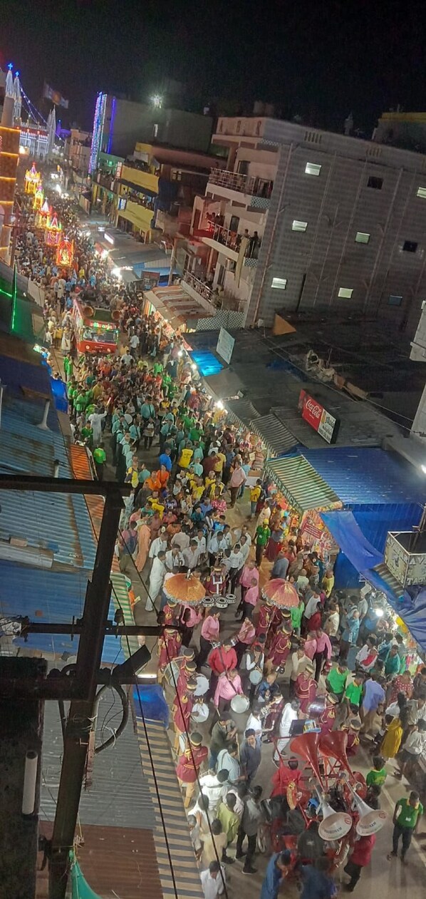 A crowded street scene at night with people and vehicles. - Hotel King Palace (Kilvelur)