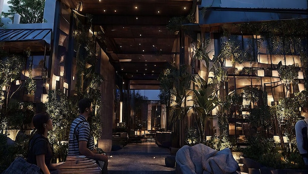 A modern building with a covered entrance, large windows, and outdoor seating areas. - Hotel King Palace (Kilvelur)