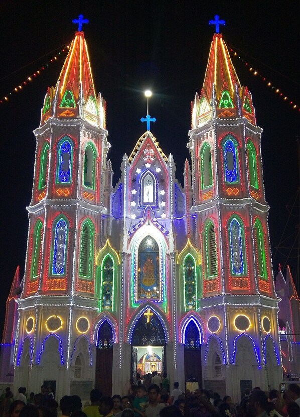 A church with two towers, each topped with a cross, and a central entrance with a statue.