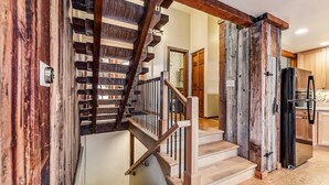 A staircase with wooden railings and a modern kitchen with a refrigerator and cabinets. - Dillon Retreat with Lake Views and Private Hot Tub (Dillon)
