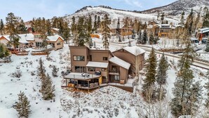A modern multi-story house with a balcony and a deck, surrounded by snow-covered trees and a mountain in the background. - Dillon Retreat with Lake Views and Private Hot Tub (Dillon)