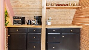 A kitchenette with a built-in oven, coffee maker, and a shelf with mugs. - Cozy A-Frame High in The Tree Tops (Crestline)
