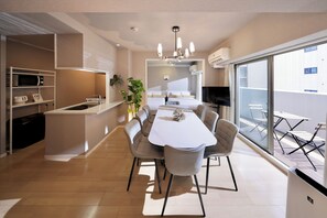 A modern kitchen with a dining area, large windows, and a view of the city.