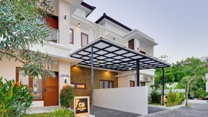A modern hotel with a covered entrance, a signboard, and well-maintained landscaping. - Villa Prinz near Nusa Dua Beach (Nusa Dua)