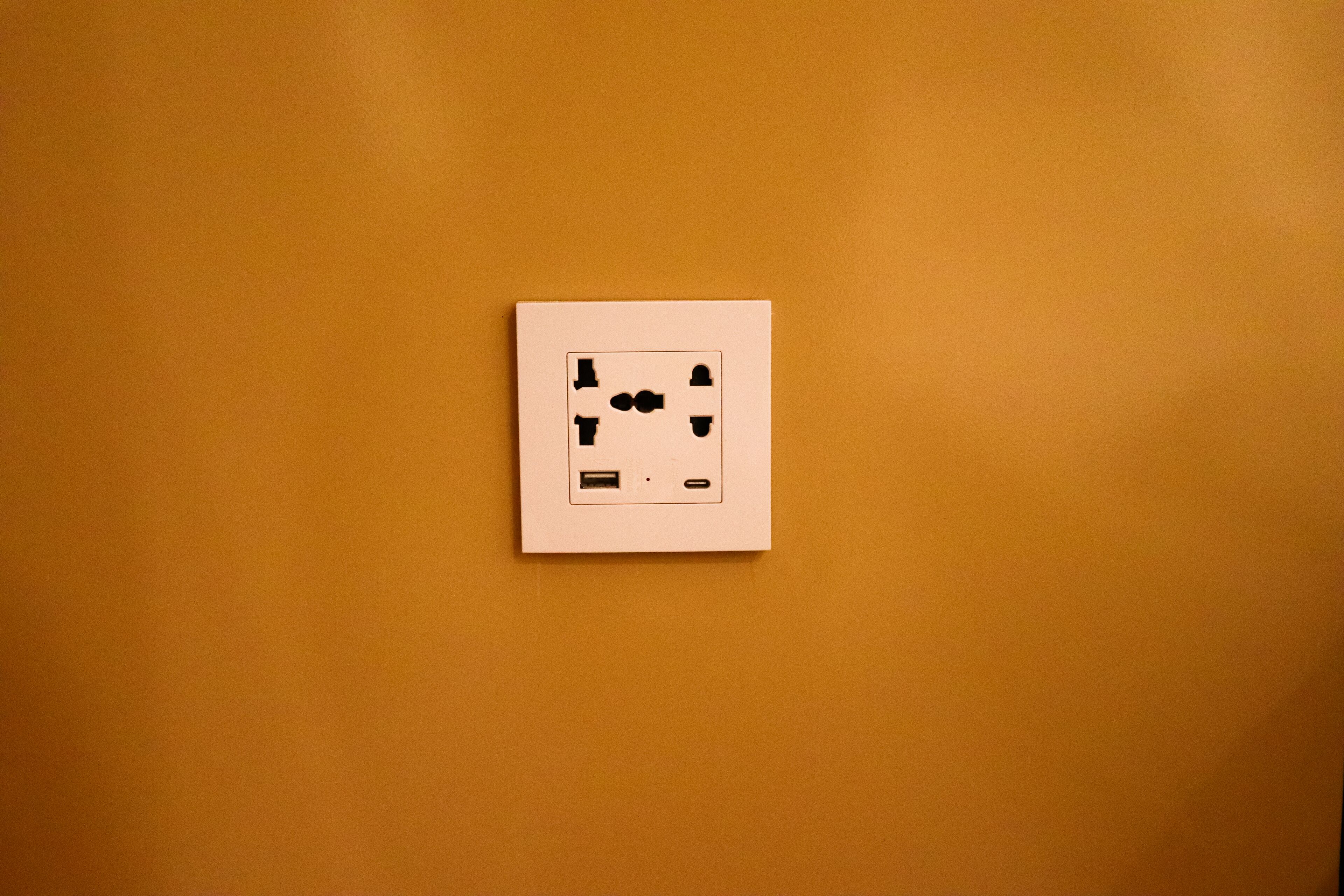 Un enchufe de pared con puerto USB y toma de corriente estándar.
