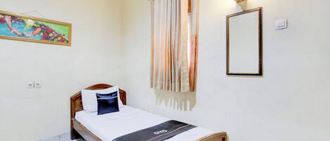 A single bed with a wooden frame, white bedding, and a black accent. A painting is on the wall, and a mirror is above the bed.