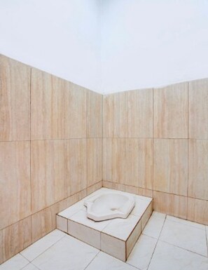 A small, enclosed bathroom with a single toilet and a tiled floor. - Collection O Stasiun Pekalongan Near Stasiun Kereta Api Formerly Hotel Indah (Pekalongan)