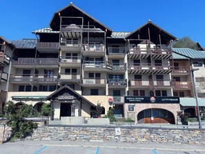 Et hotel med flere etager, altaner, en facade af sten og skilte til udlejning og salg.