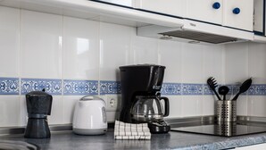 A kitchen counter with a coffee maker, a kettle, and a knife block. - Apartment 'Beachfront Apt Torrox Costa' with Sea View, Wi-Fi and Air Conditioning (Torrox)