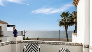 A balcony with a view of the sea, a palm tree, and a decorative blue object. - Apartment 'Beachfront Apt Torrox Costa' with Sea View, Wi-Fi and Air Conditioning (Torrox)