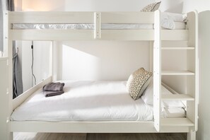 A bunk bed with a lower bunk, a pillow, and a folded blanket.