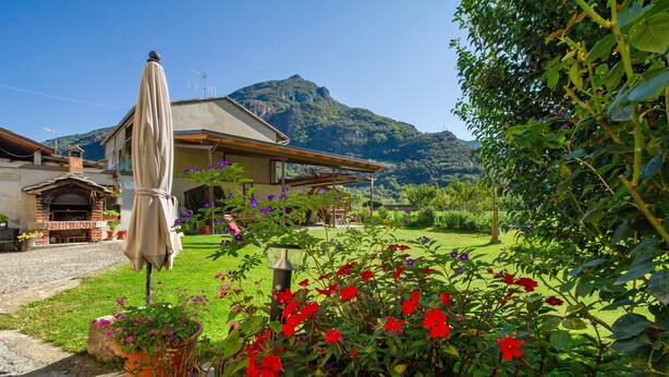 A house with a garden, a patio, and a mountain in the background. - Private room with mountain view, shared terrace and Wi-Fi (Pont-Saint-Martin)