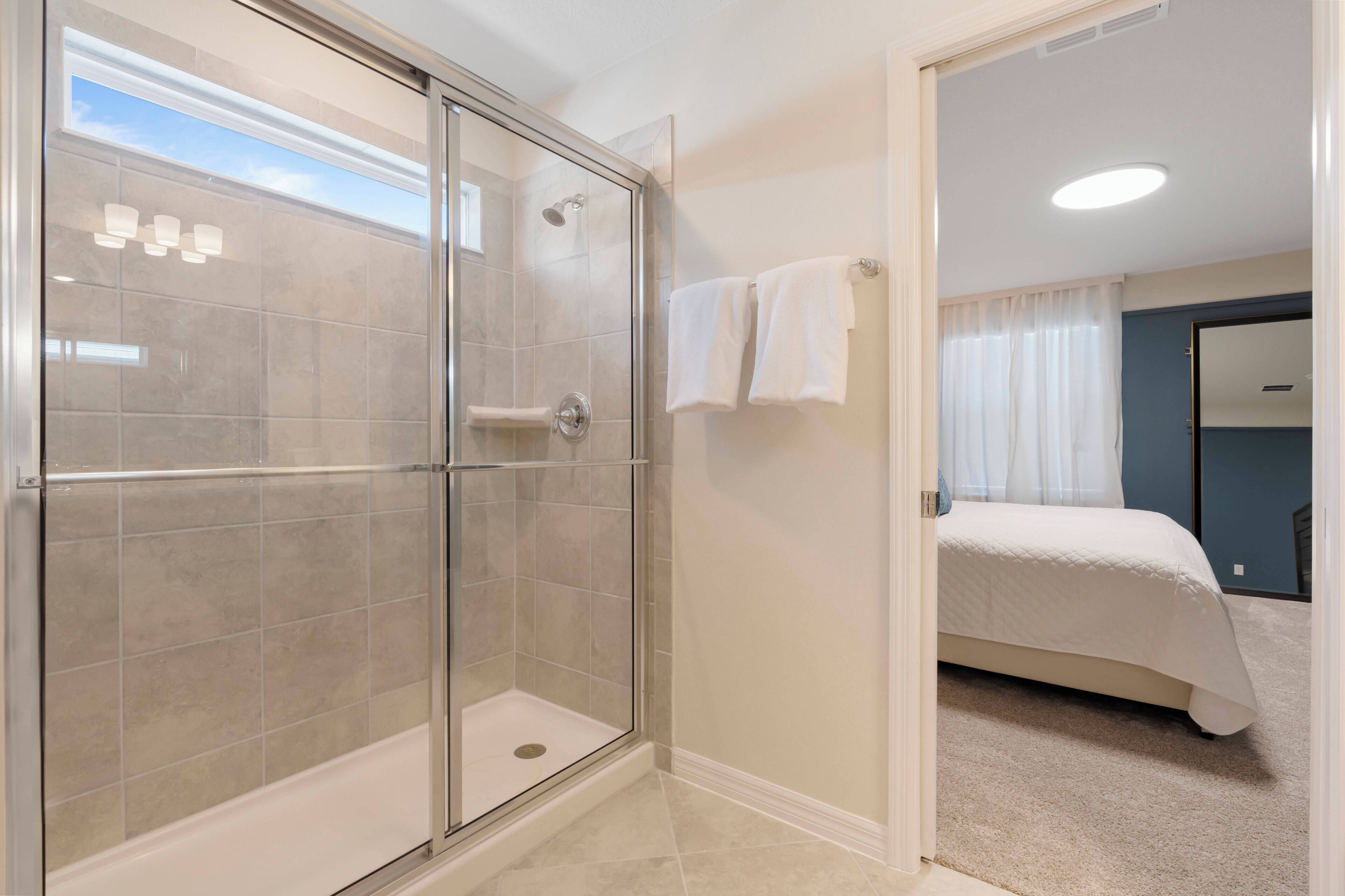 A modern bathroom with a glass-enclosed shower, a bathtub, and a visible toilet.