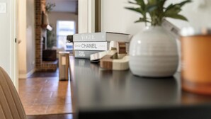 Una mesa de comedor con un jarrón y libros.