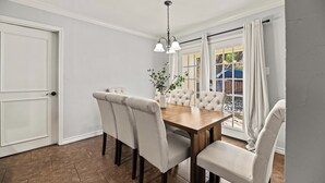 Un comedor con una mesa de madera y seis sillas tapizadas.