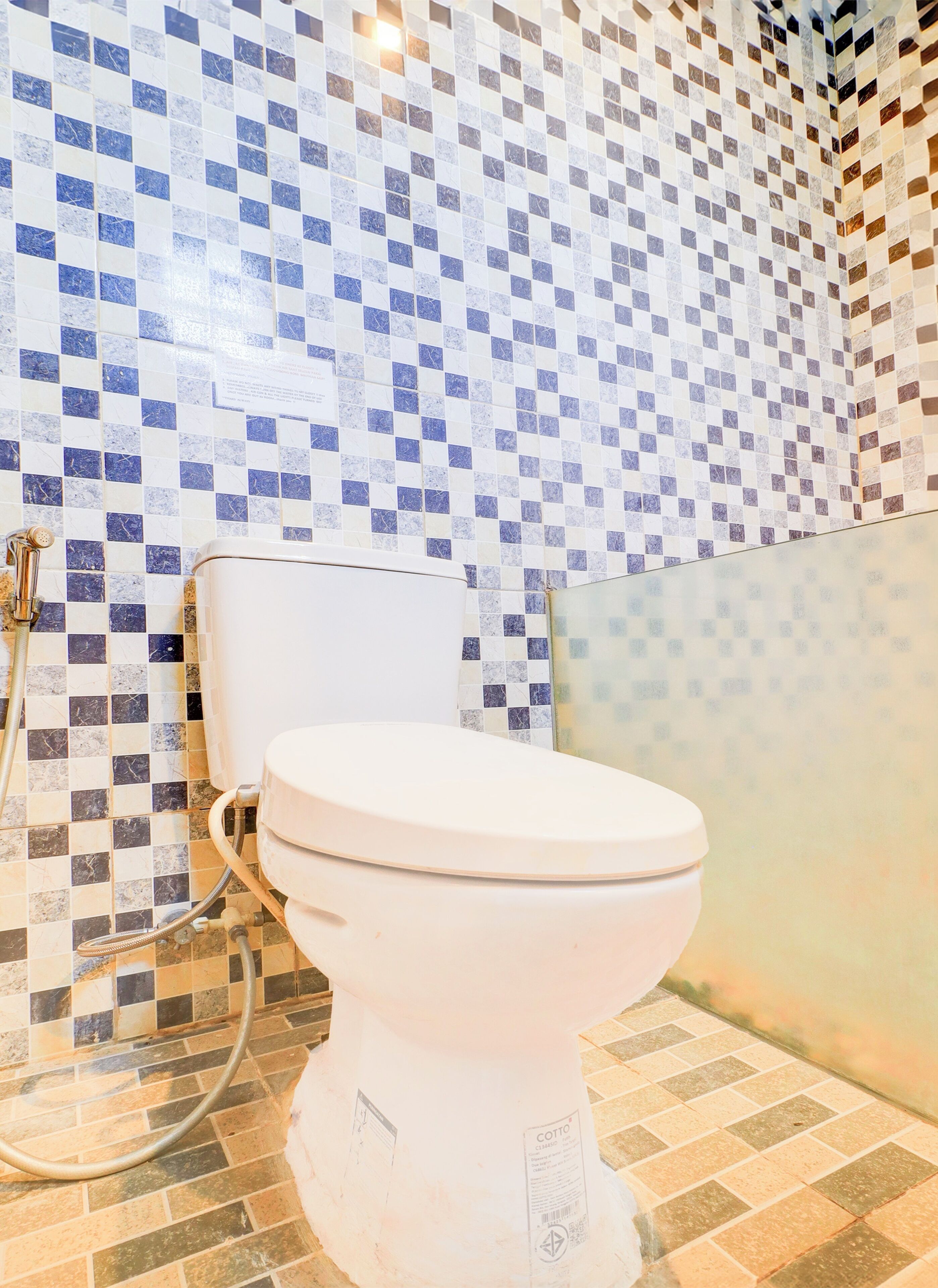 Ein Badezimmer mit Toilette, Dusche und Fliesen.