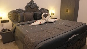 Una cama bien hecha con una colcha acolchada, un cabecero decorativo y una mesita de noche con una lámpara.