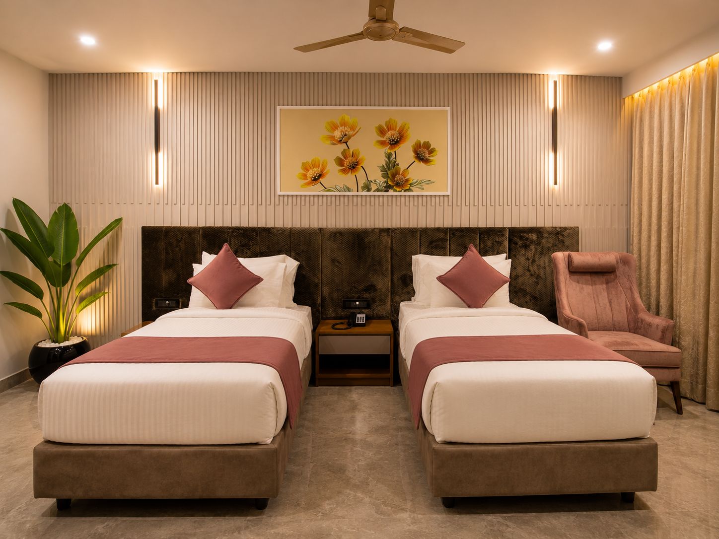 A hotel room with two beds, a ceiling fan, a nightstand, a chair, a potted plant, and a painting on the wall.