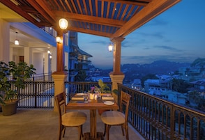 Un espacio para comer al aire libre con vista a un paisaje urbano al anochecer.