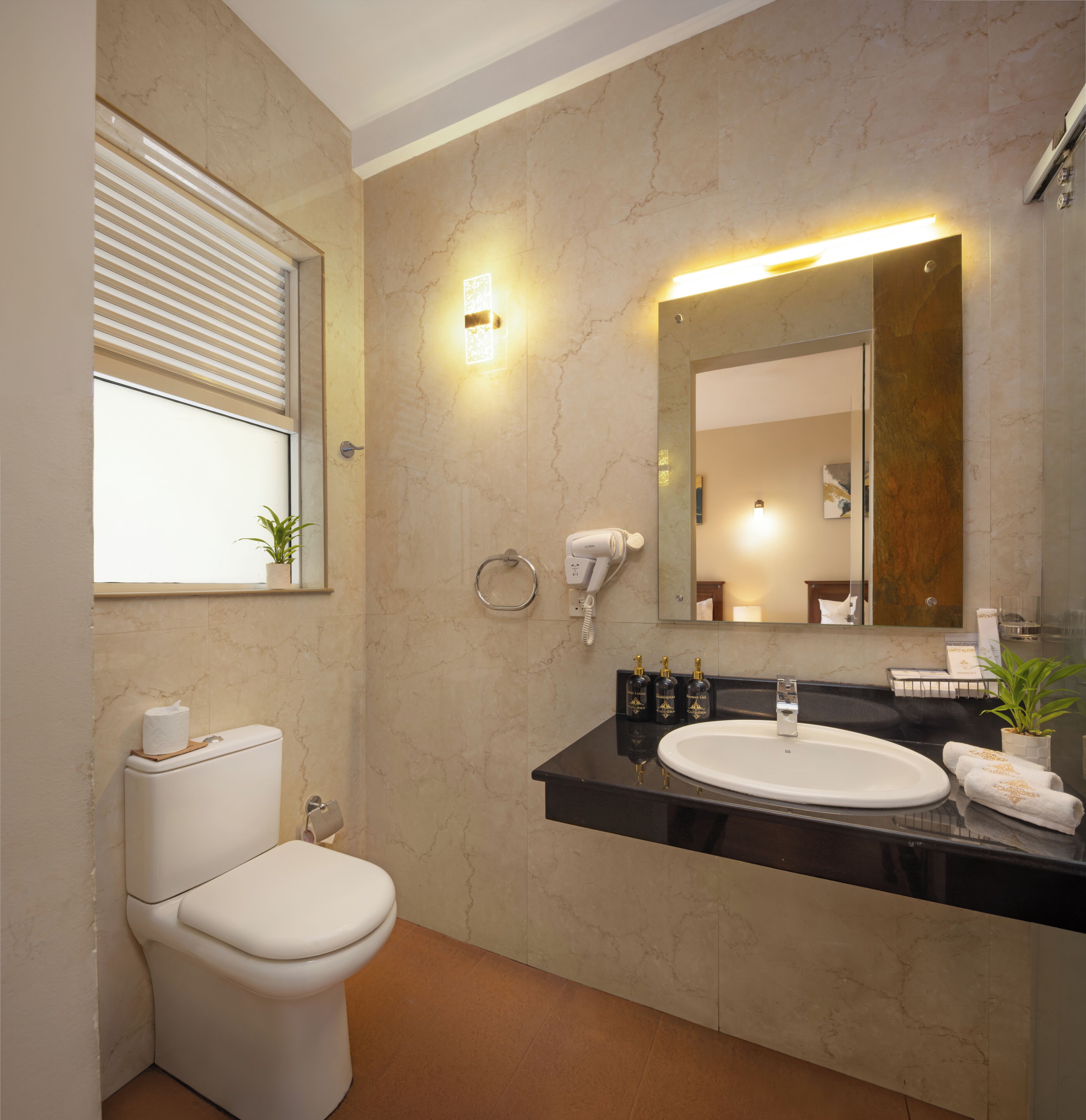 A modern bathroom with a toilet, sink, and mirror.