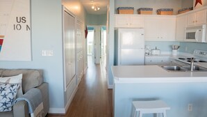 A modern kitchen with white cabinets, a stainless steel sink, and a central island.