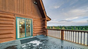 A wooden log cabin with a glass door and a balcony. - < 1 Mi to Kenai River: Spacious Cabin w/ Deck! (Sterling)