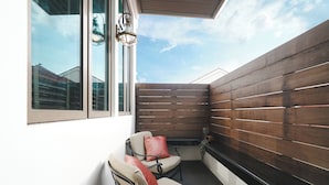 Ein Balkon mit zwei Stühlen und einer Holzwand.
