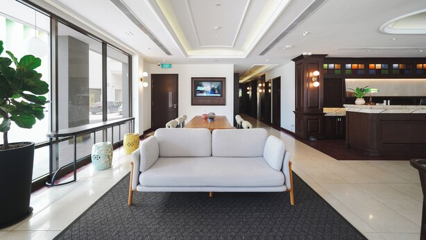 Eine moderne Hotelhalle mit einer großen Couch, einem Esstisch und einer Küchenzeile.