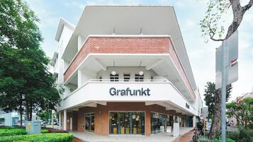 Un edificio moderno con un llamativo letrero 'Grafunkt', que presenta un techo plano, fachada de ladrillo y grandes ventanales.