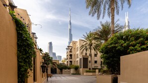 A paved pathway flanked by buildings with a view of the Burj Khalifa. - Stylish & Spacious Apartment in Downtown Dubai (Dubai)