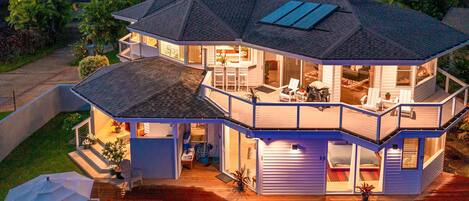 A two-story house with a swimming pool, outdoor seating, and a covered patio.