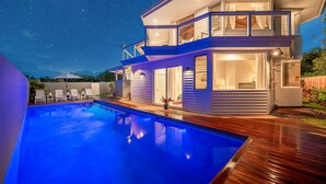 A two-story house with a swimming pool, wooden deck, and a night sky with stars. - Hanalei Vista Estate (Princeville)