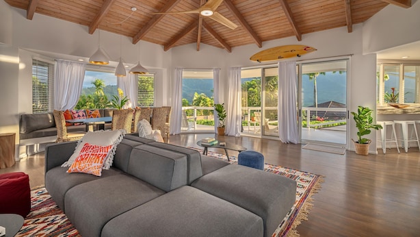 A spacious living area with a high ceiling, large windows, and a view of the outdoors. - Hanalei Vista Estate (Princeville)