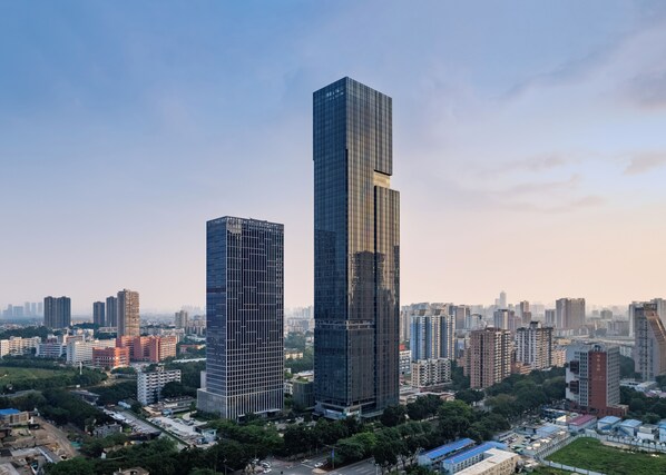 A high-rise building with a modern glass facade, surrounded by other high-rise buildings in an urban setting.