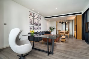 A modern living room with a curved white chair, a black sofa, and a dining area with a wooden table and chairs. - UrCove by Hyatt Guangzhou Canton Tower Exhibition Center (Guangzhou)