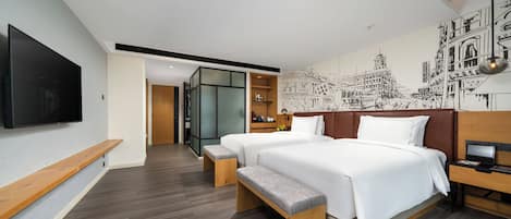 A modern hotel room with two beds, a TV, a desk, and a mural.