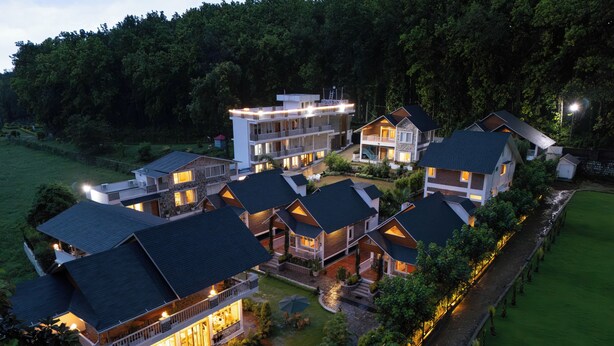 A multi-story hotel with balconies, a swimming pool, and a well-maintained garden. - Megha Resort & Villas, Dehradun-Where Nature Pampers You (Vikasnagar)