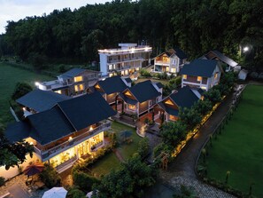 A multi-story hotel with balconies, a swimming pool, and a well-maintained garden. - Megha Resort & Villas, Dehradun-Where Nature Pampers You (Vikasnagar)
