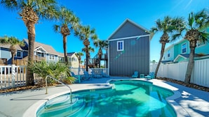 A swimming pool surrounded by palm trees and houses. - Salty Seas | Shared Pool, Beach Gear & Prime Location Near Port Aransas Beaches (Port Aransas)