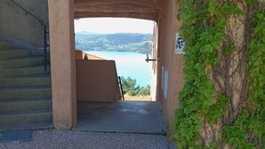A pathway leading to a terrace with a view of a lake and mountains. - Le Cigalou (Sainte-Croix-du-Verdon)