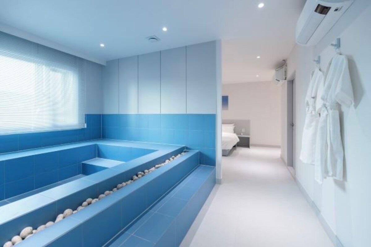 A modern bathroom with a large bathtub, a shower area, and a walk-in shower.