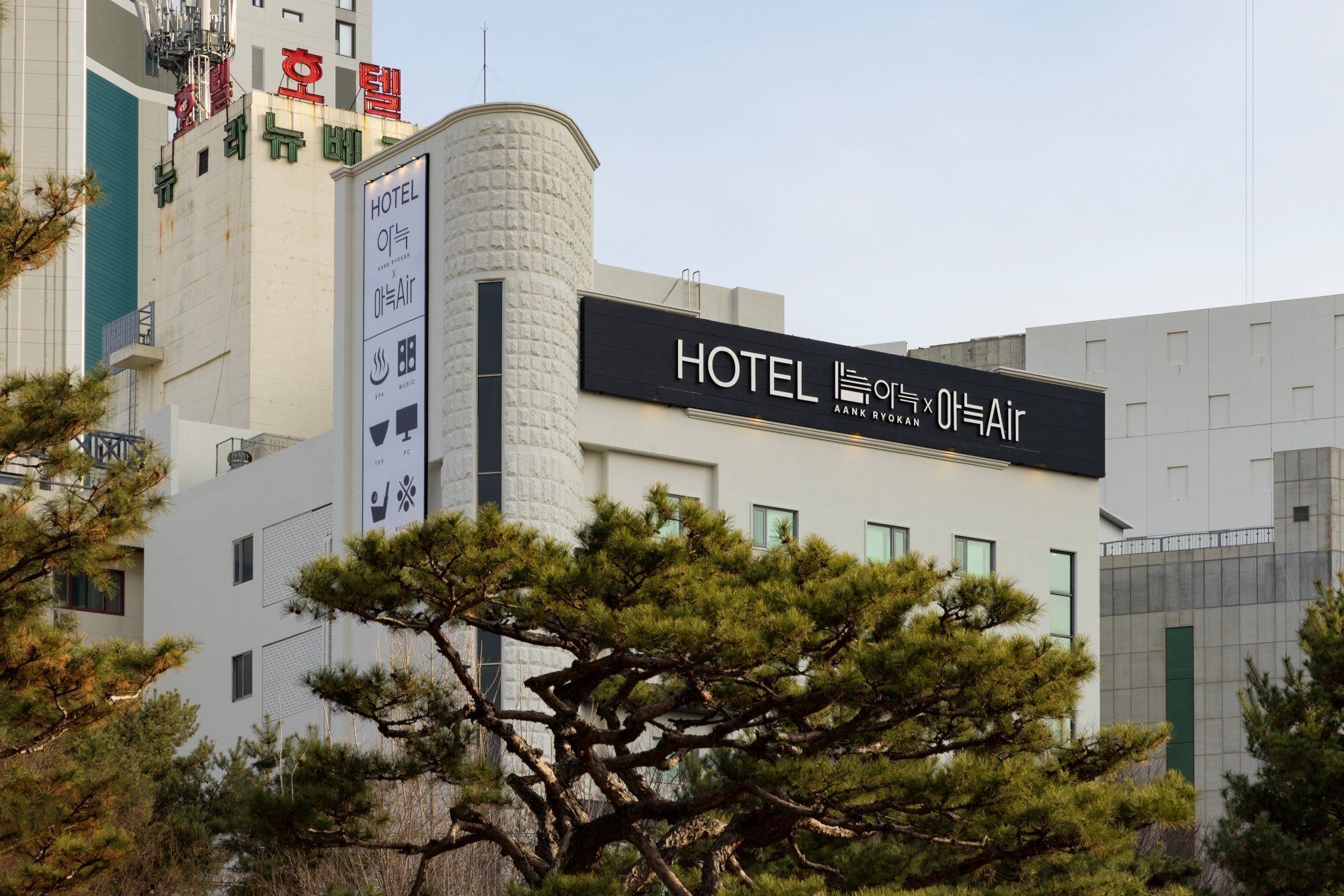 A modern hotel building with a prominent sign indicating it is a Hotel Air Aank RYOKAN.