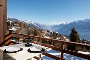 Dine amidst breathtaking mountain views on a tranquil balcony.