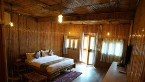 A room with a bed, wooden furniture, and a desk.