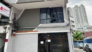 Un edificio de varios pisos con fachada geométrica, ventanas amplias con cortinas y un letrero visible de 'Spectra Travel & Tours'.