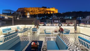 Eine Dachterrasse mit Sitzgelegenheiten und Blick auf ein historisches Gebäude.